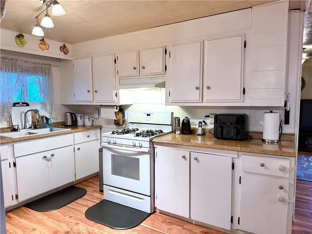 a kitchen with granite countertop white cabinets and white appliances