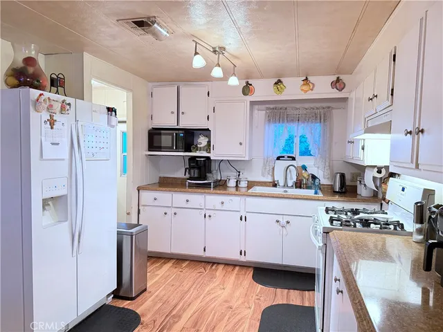 a kitchen with cabinets a sink a window and stainless steel appliances