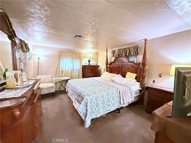 a bedroom with a bed couch and a window