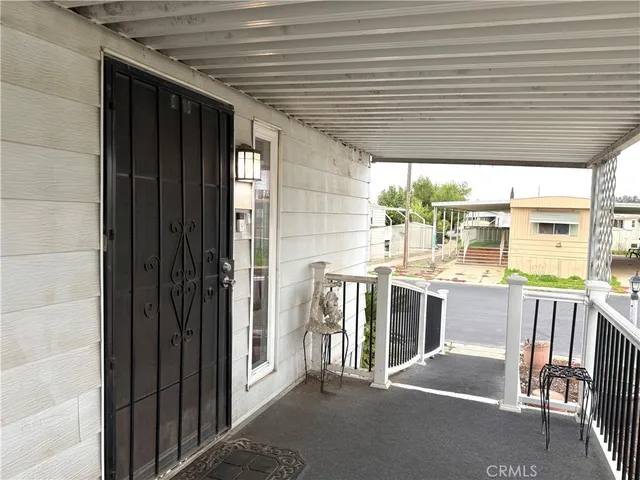 a view of a porch with furniture and floor to ceiling window