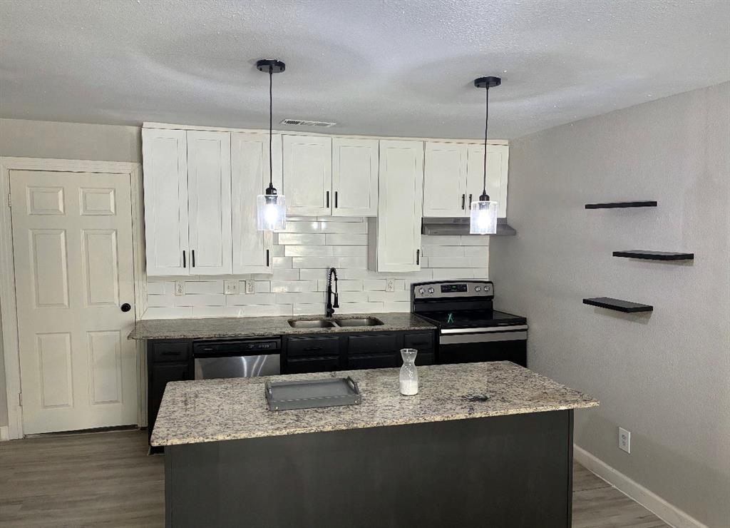 109 Lydia Street Terrell, TX 75160 - Photo 15 of 15 a kitchen with granite countertop kitchen island stainless steel appliances a sink a stove a refrigerator and cabinets