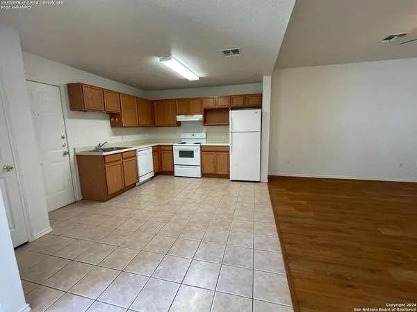 a large kitchen with cabinets and wooden floor