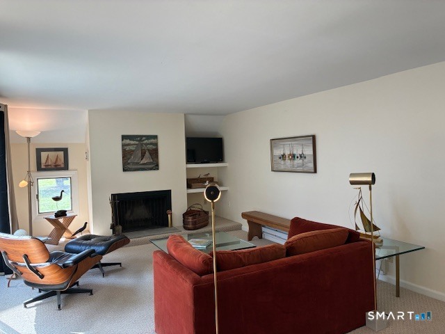7 River Colony, Unit 7 Guilford, CT 06437 - Photo 11 of 23 a living room with furniture a flat screen tv and a fireplace