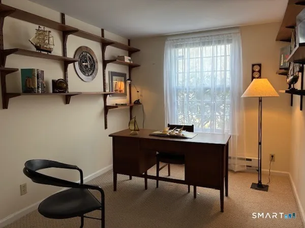 a view of a workspace with furniture and a window