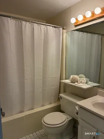 a bathroom with a toilet and a shower curtain