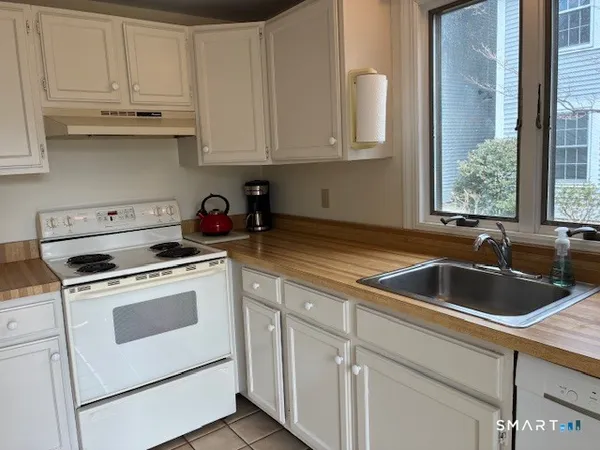 a kitchen with white cabinets sink and appliances