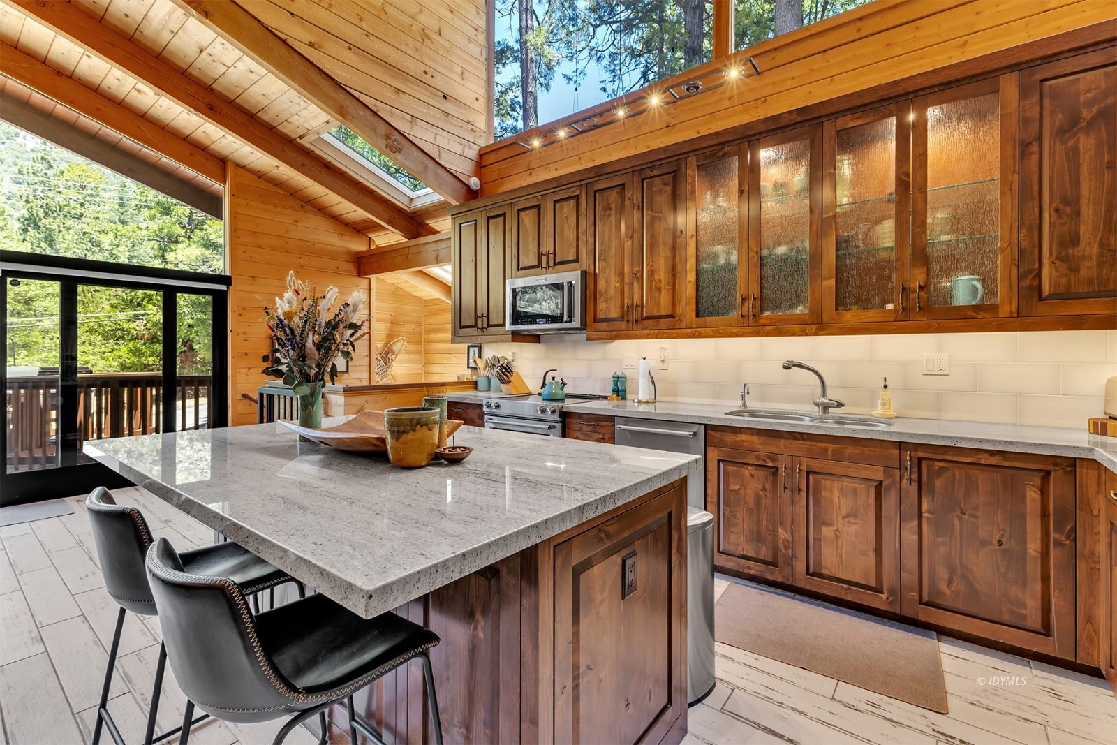 24924 Fern Valley Road Idyllwild, CA 92549 - Photo 33 of 72 a kitchen with granite countertop a sink and wooden cabinets