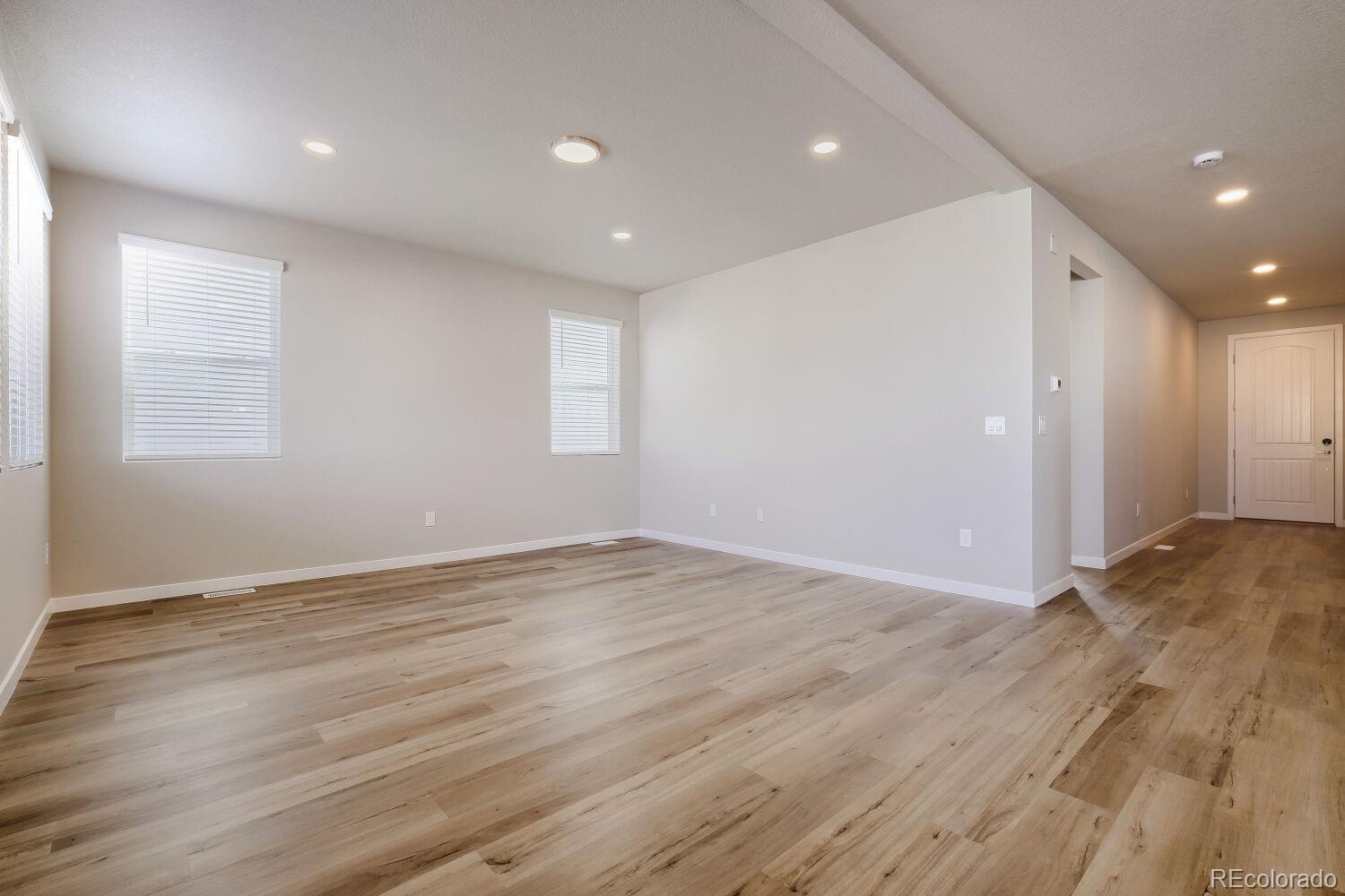 471 Atchison Way Calhan, CO 80808 - Photo 9 of 31 an empty room with wooden floor and windows
