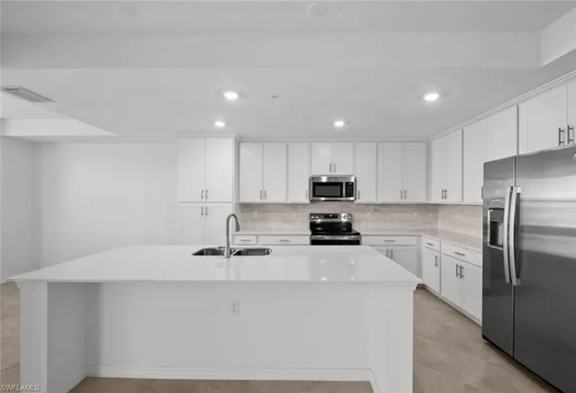a kitchen with stainless steel appliances a table chairs and a refrigerator