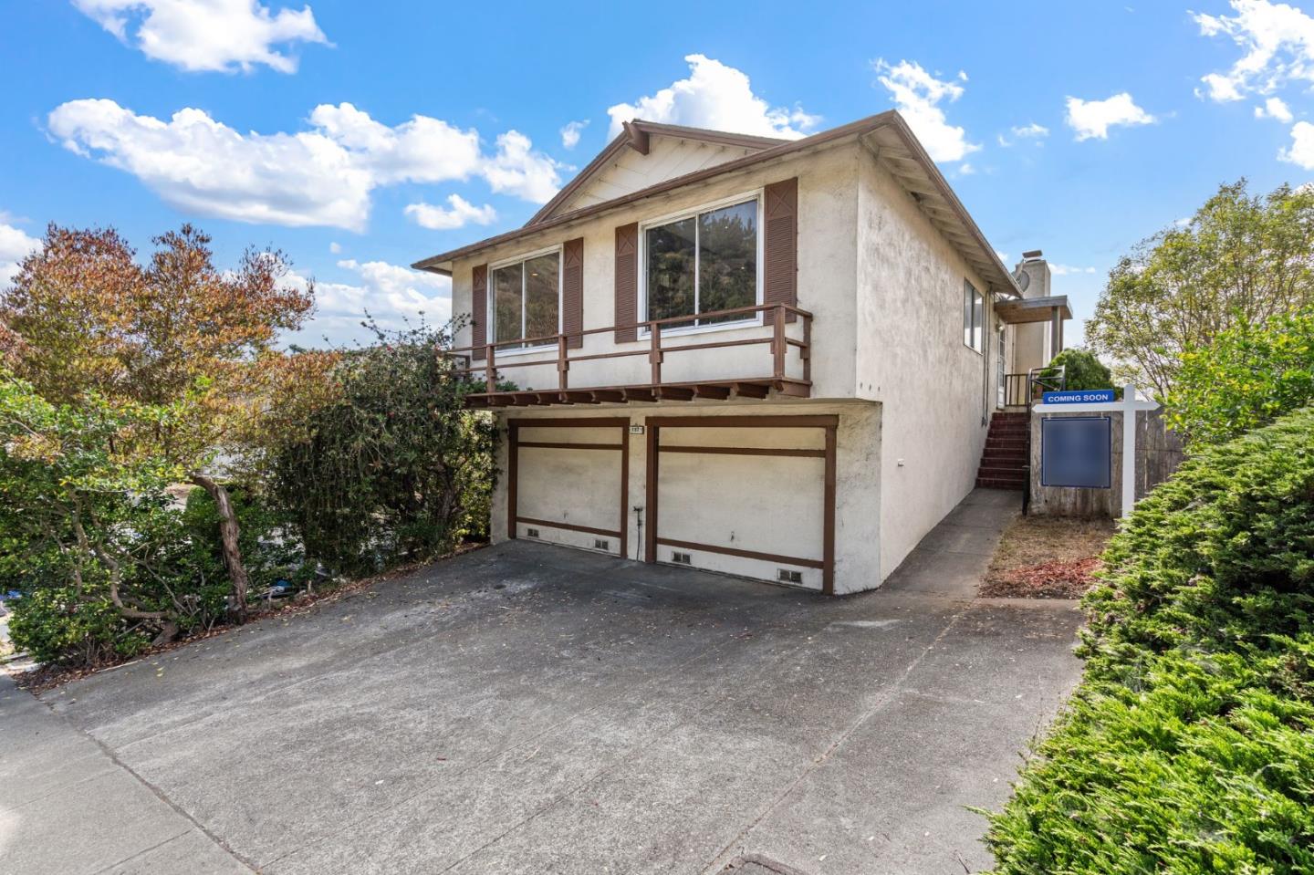 a front view of a house with yard garage and outdoor seating