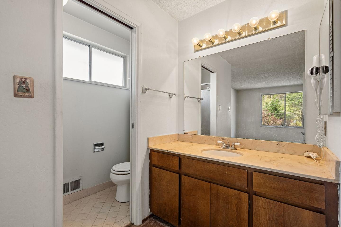 107 Hickey Boulevard Pacifica, CA 94044 - Photo 14 of 29 a bathroom with a sink a toilet and a mirror