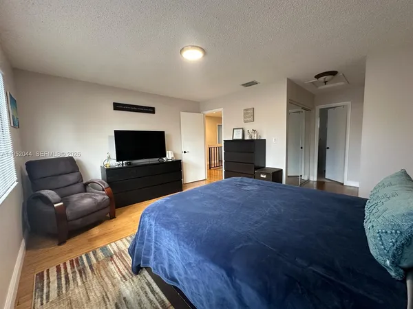 a bedroom with a bed and wooden floor