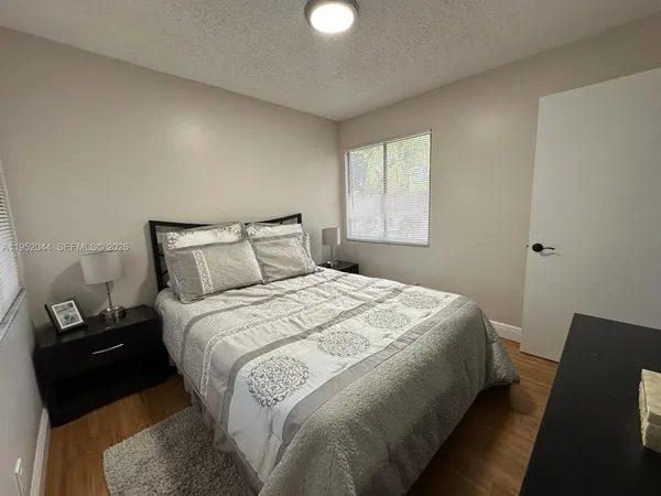a bedroom with a bed and painting on the wall