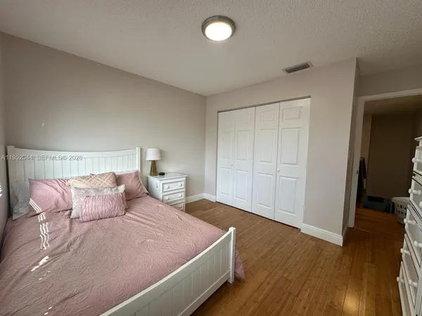 a bedroom with a bed and a flat tv screen on dresser