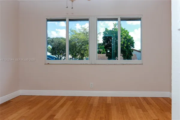 a view of a small space with wooden floor and a window