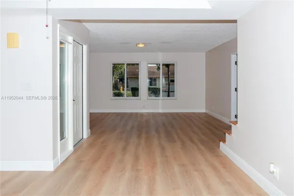 a view of a room with wooden floor and windows