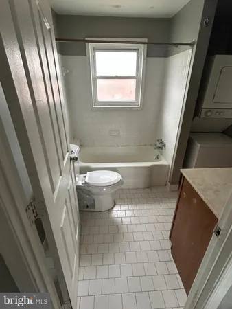 a bathroom with a sink a toilet a window and tub