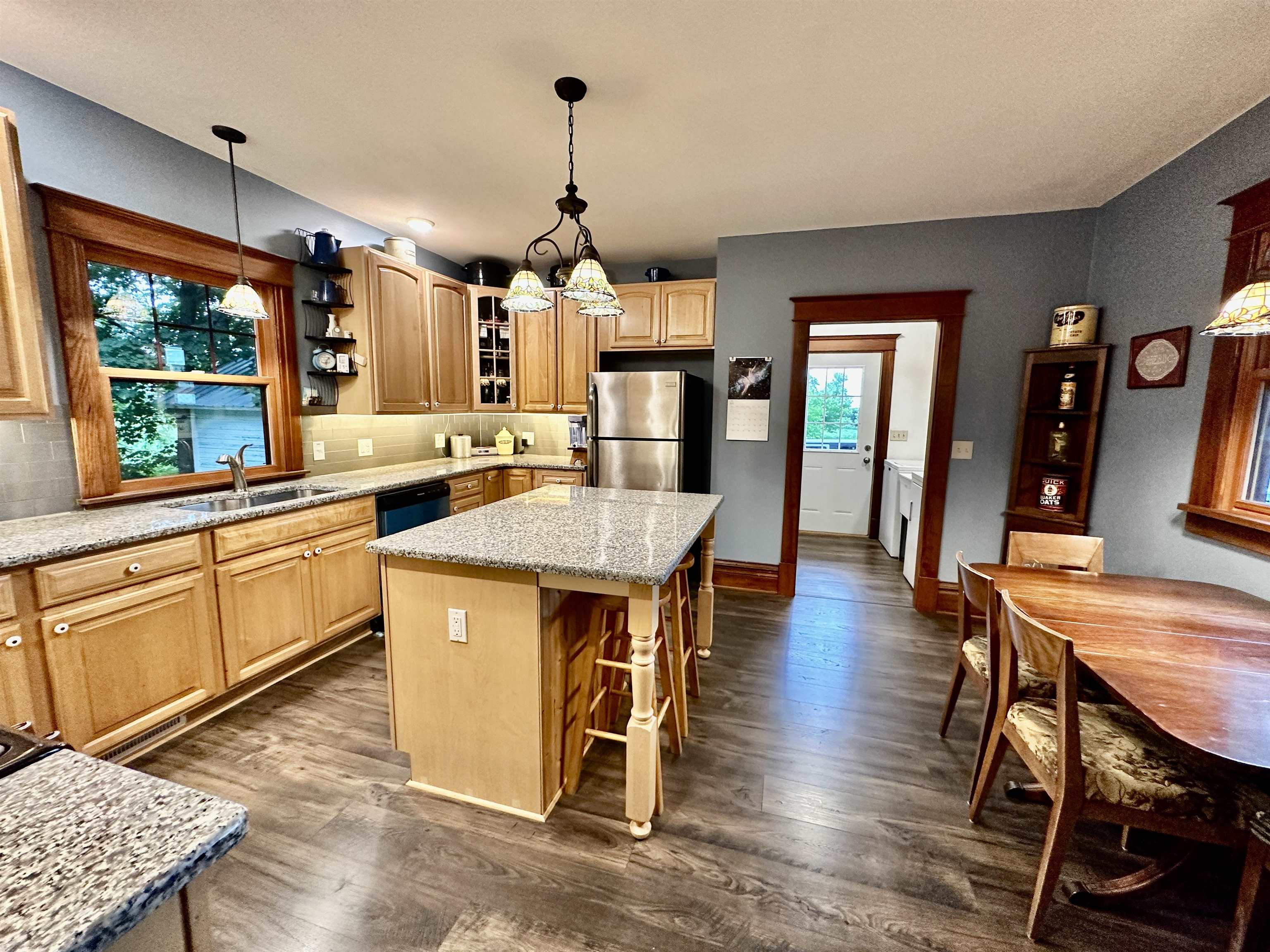 4415 Genoa Road Belvidere, IL 61008 - Photo 17 of 51 a kitchen with granite countertop a stove a sink a dining table and chairs with wooden floor