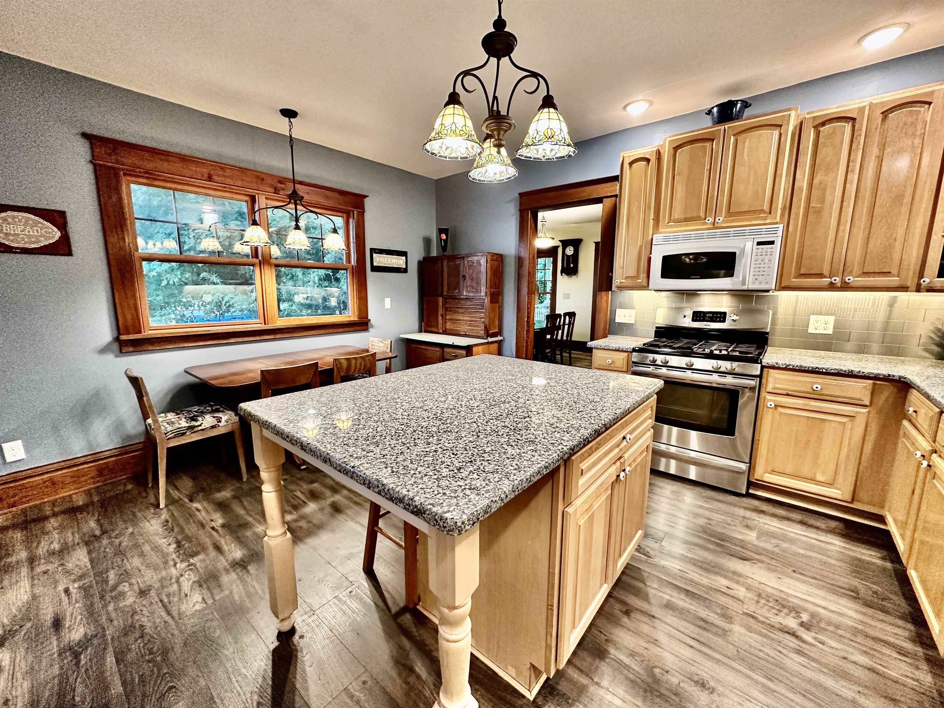 4415 Genoa Road Belvidere, IL 61008 - Photo 19 of 51 a kitchen with stainless steel appliances granite countertop a stove top oven a sink dishwasher a dining table and chairs with wooden floor