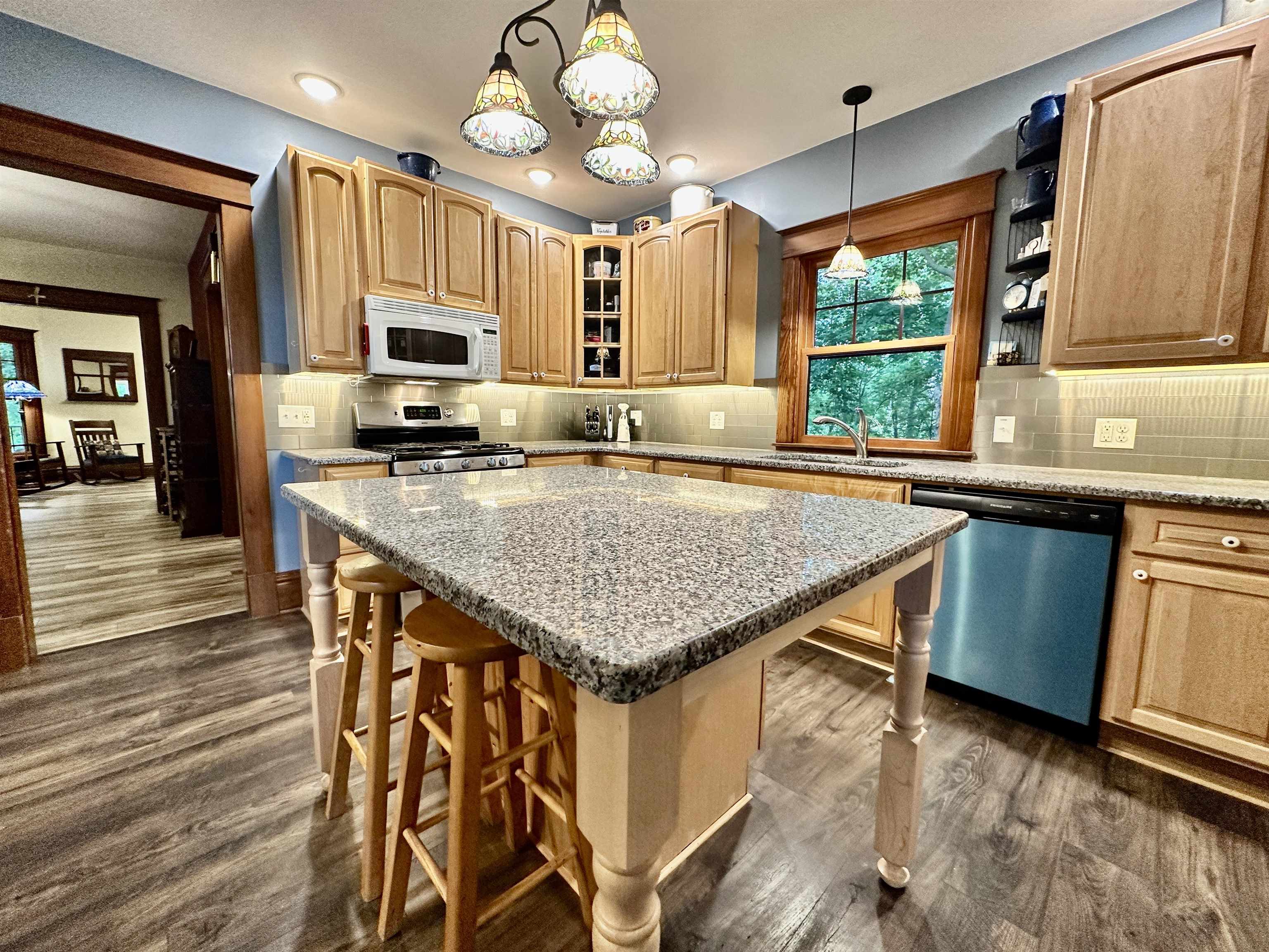 4415 Genoa Road Belvidere, IL 61008 - Photo 20 of 51 a kitchen with stainless steel appliances kitchen island granite countertop a table chairs in it and wooden floors