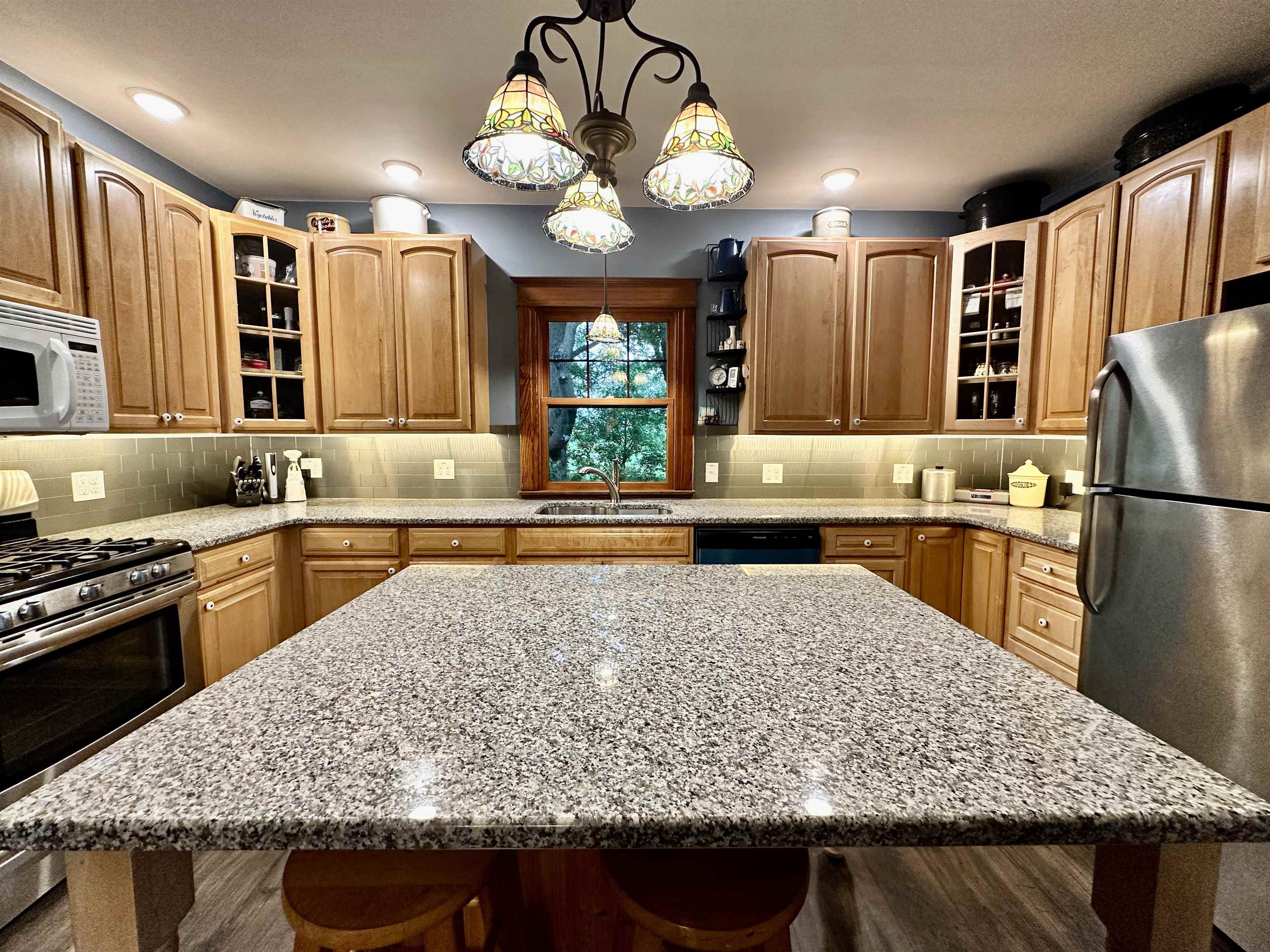 4415 Genoa Road Belvidere, IL 61008 - Photo 21 of 51 a kitchen with kitchen island granite countertop wooden cabinets and a refrigerator