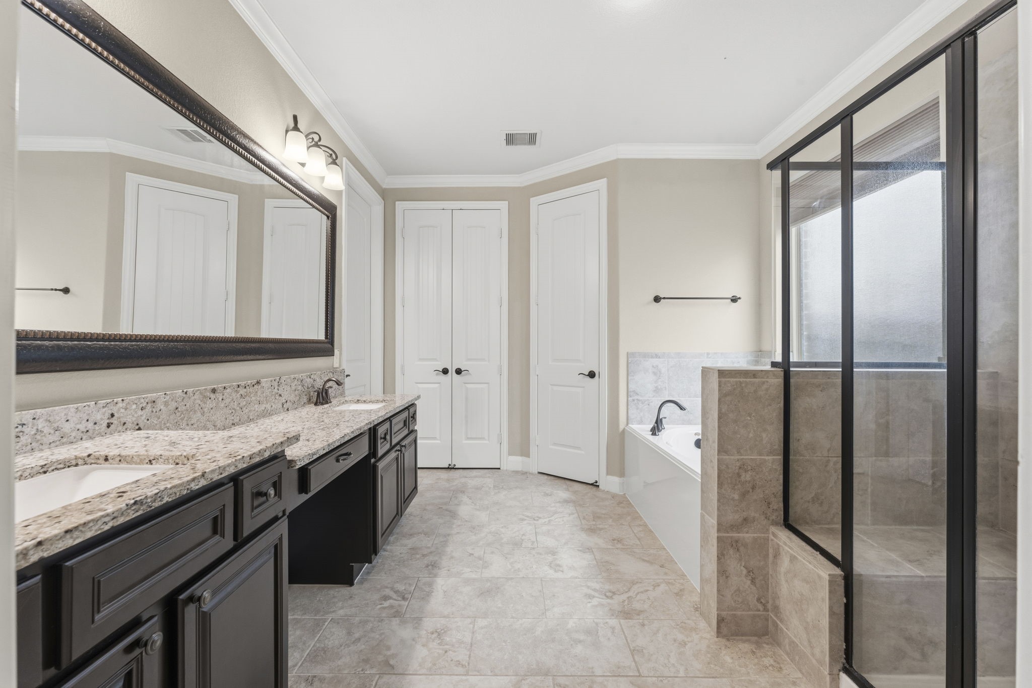 25210 Gaddis Oaks Drive Spring, TX 77389 - Photo 20 of 50 a spacious bathroom with a granite countertop sink mirror and a bathtub