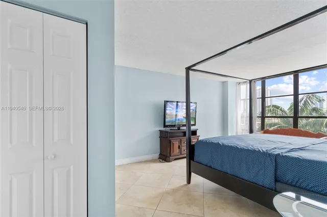 a bedroom with a bed and large windows