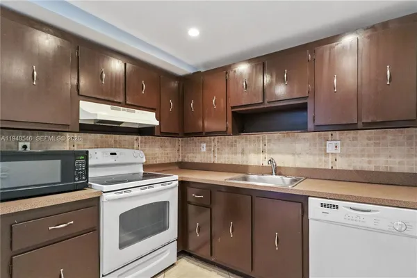 a kitchen with a sink a stove and cabinets