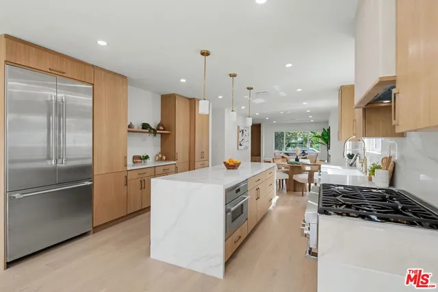 a kitchen with stainless steel appliances a stove a sink and a refrigerator