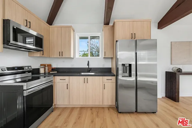 a kitchen with stainless steel appliances granite countertop a stove a refrigerator and a microwave