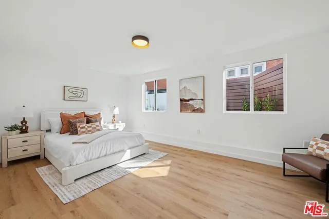 a spacious bedroom with a bed and wooden floor