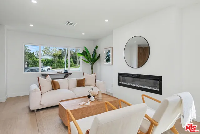 a living room with furniture a large window and a fireplace