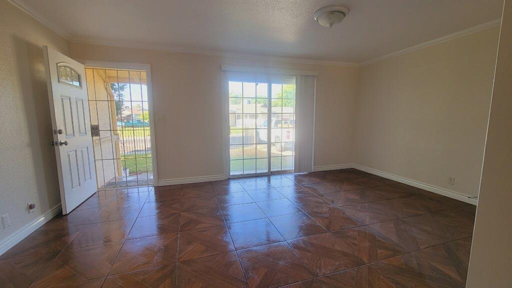 641 Brimmer Road Merced, CA 95341 - Photo 7 of 21 an empty room with wooden floor and windows