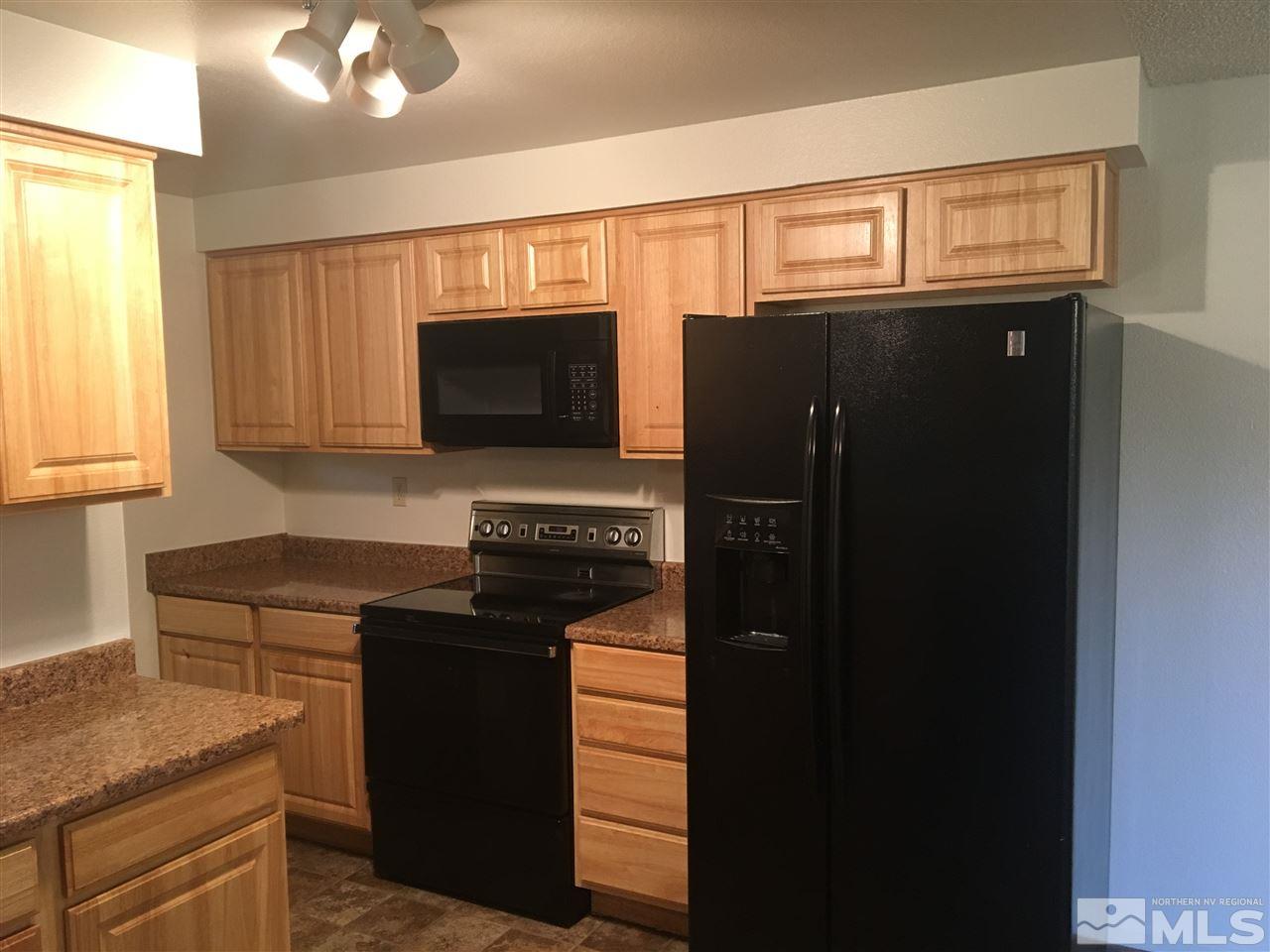 6655 Lotus Street Reno, NV 89506 - Photo 4 of 18 a kitchen with a refrigerator stove and cabinets