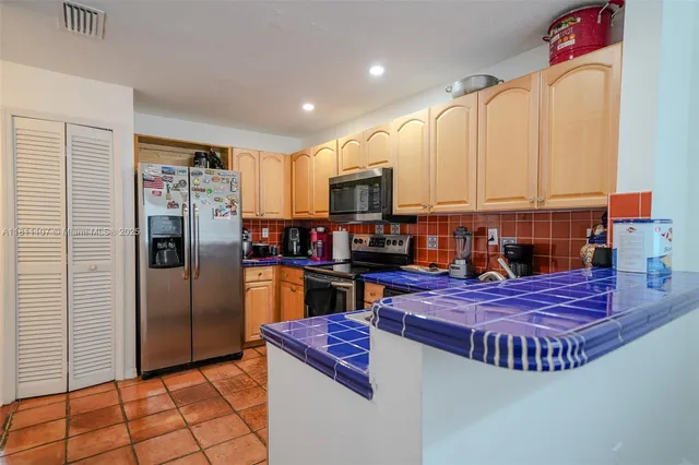 a living room with stainless steel appliances furniture and a window