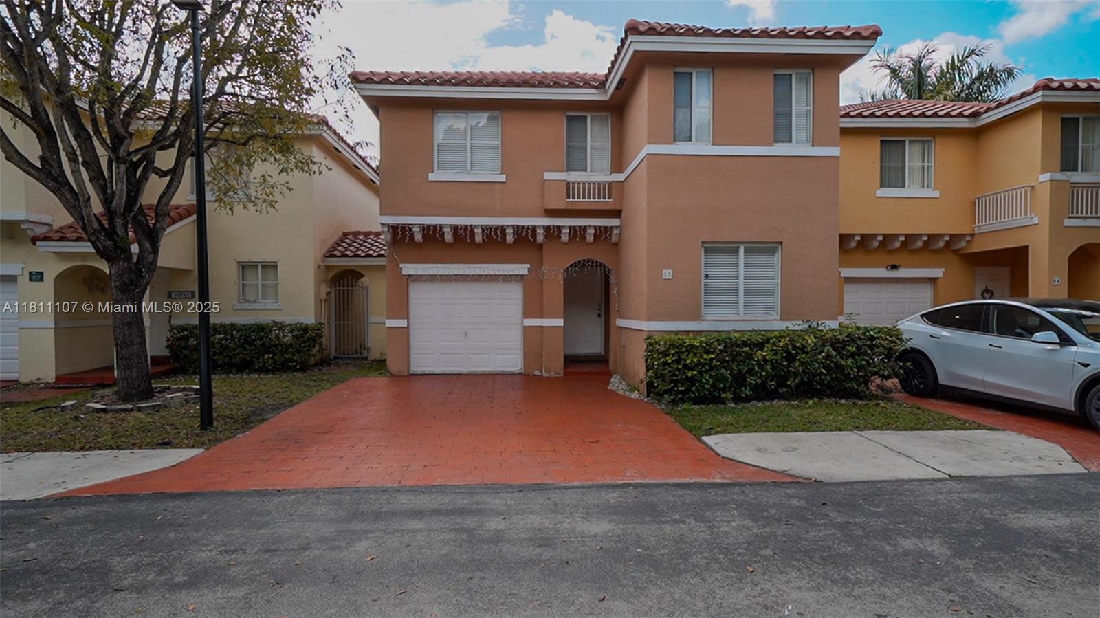 14816 Southwest 104th Street, Unit 85 Miami, FL 33196 - Photo 2 of 20 a front view of a house with a yard and garage