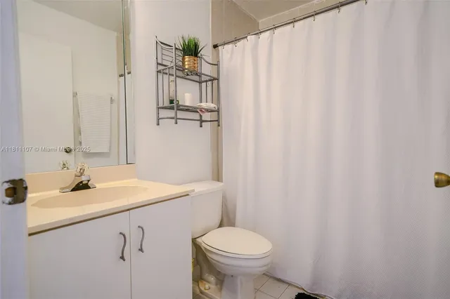 a bathroom with a sink a toilet and shower curtain