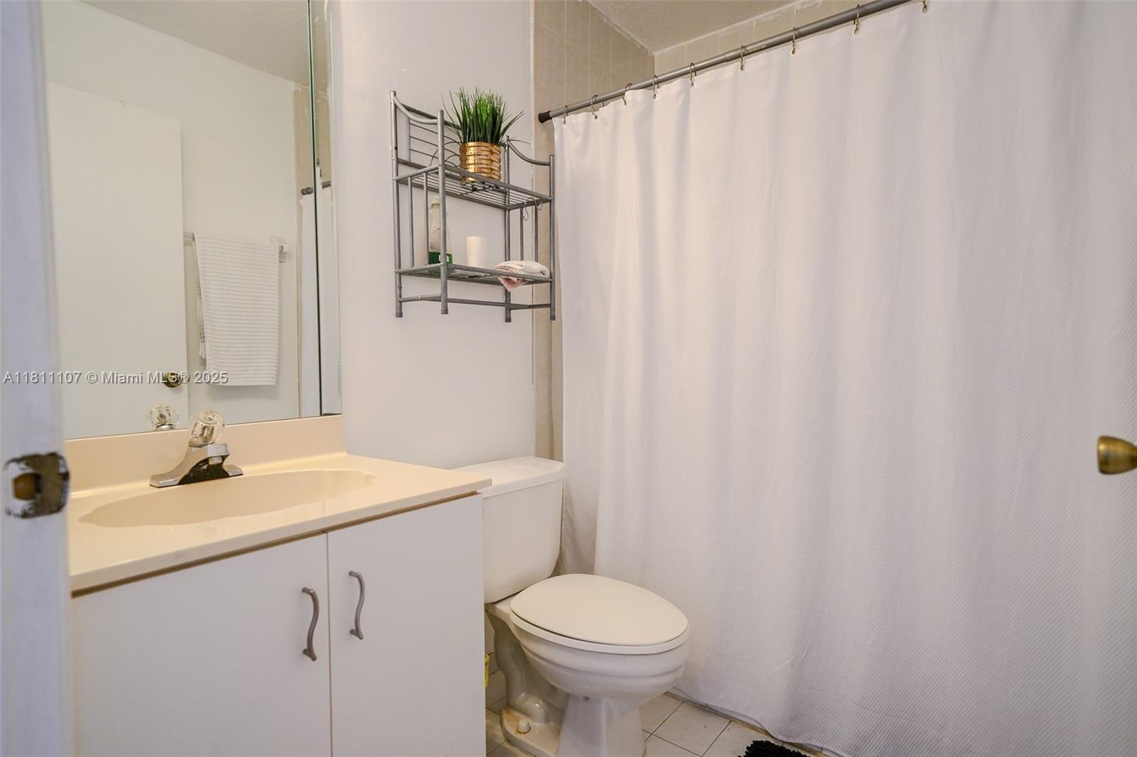 14816 Southwest 104th Street, Unit 85 Miami, FL 33196 - Photo 5 of 20 a bathroom with a sink a toilet and shower curtain