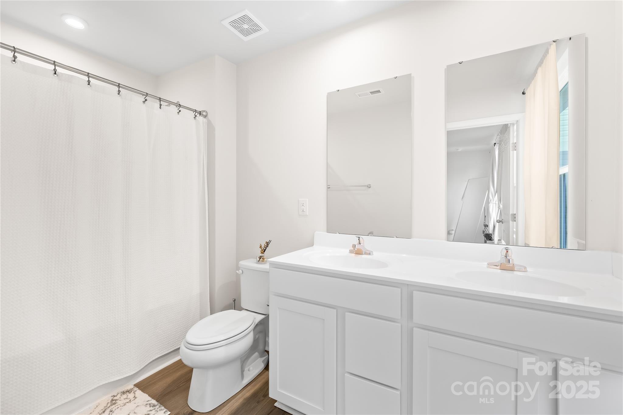4447 Wild Rdg Drive Charlotte, NC 28215 - Photo 14 of 30 a bathroom with a sink a toilet and mirror