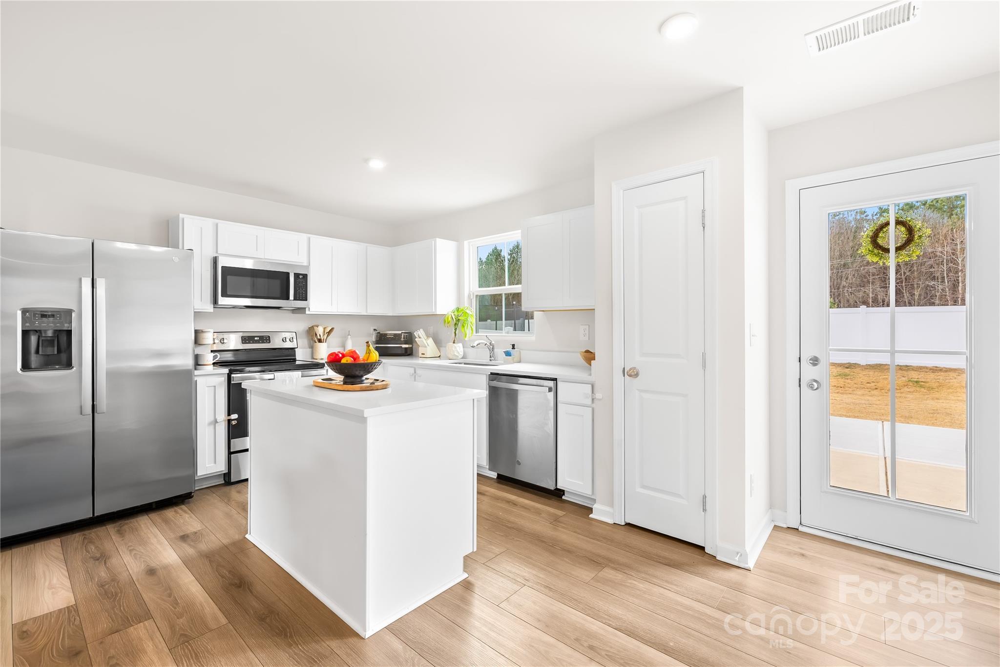 4447 Wild Rdg Drive Charlotte, NC 28215 - Photo 10 of 30 a kitchen with white cabinets and stainless steel appliances