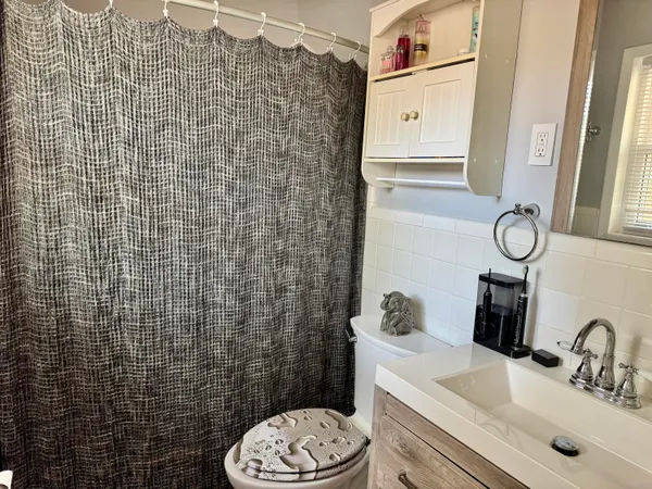 a bathroom with a sink a toilet and shower curtain