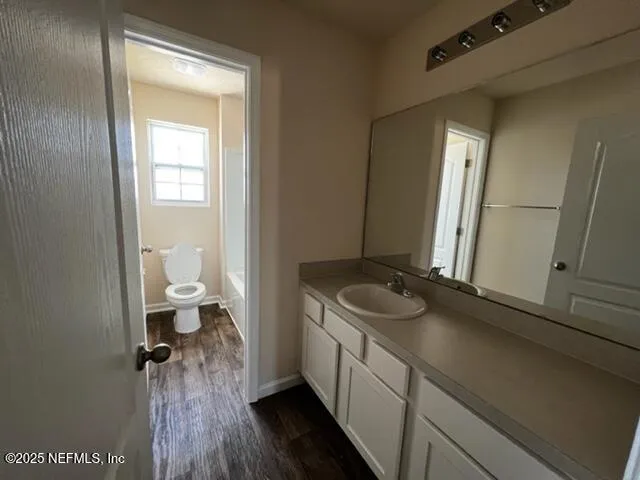 a bathroom with a granite countertop sink a toilet and a mirror