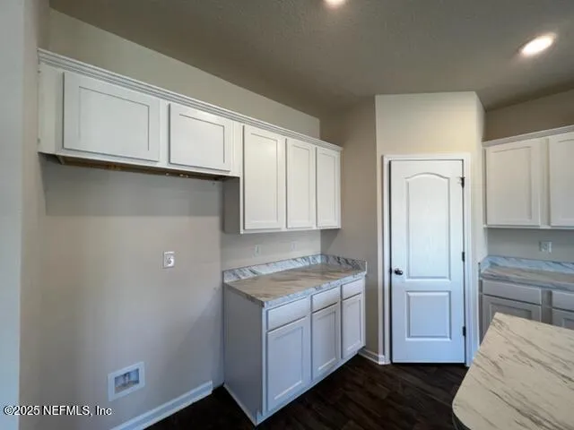 a kitchen with cabinets appliances and a window