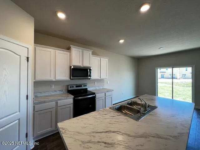 a kitchen with a stove a sink and a refrigerator