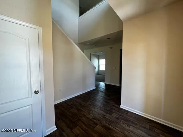 a view of a hallway with wooden floor and staircase