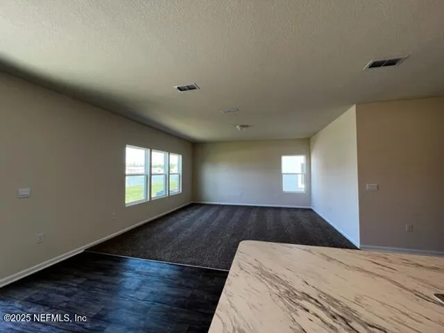 a view of a room with wooden floor and window