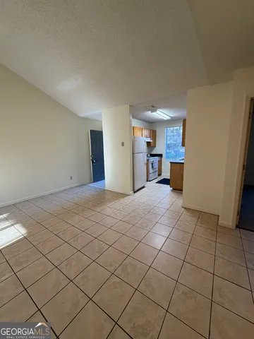 a view of a kitchen with furniture and a refrigerator
