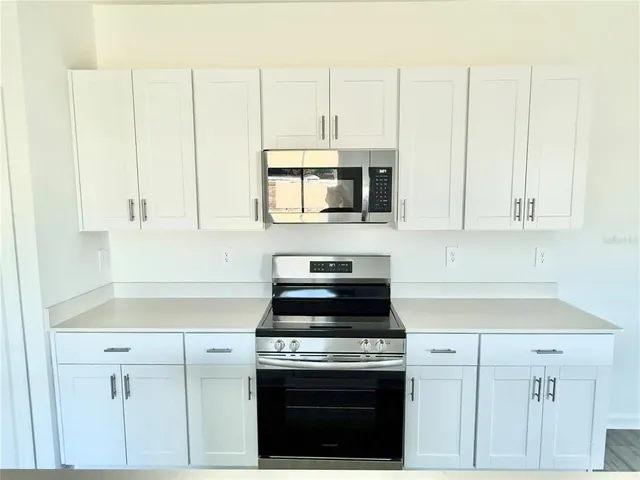 a kitchen with stainless steel appliances white cabinets and a stove