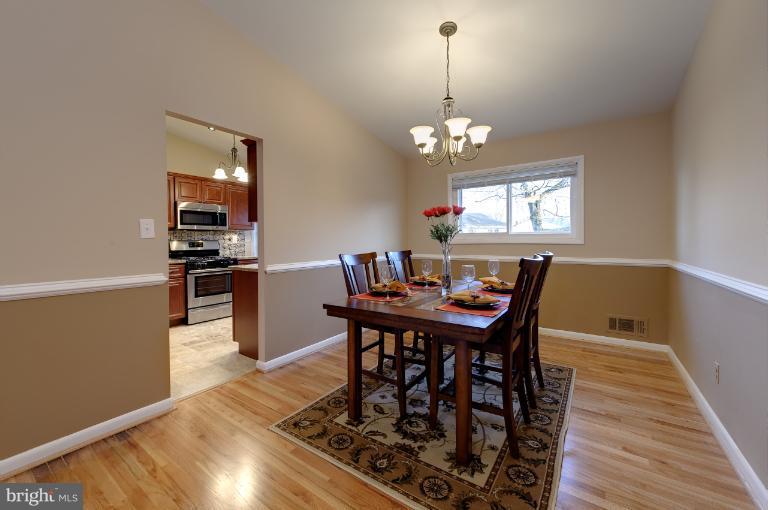 4748 Byron Road Windsor Mill, MD 21244 - Photo 22 of 27 a view of a dining room with furniture a chandelier and wooden floor
