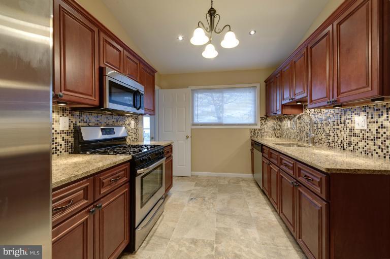 4748 Byron Road Windsor Mill, MD 21244 - Photo 27 of 27 a kitchen with stainless steel appliances granite countertop a stove top oven a sink dishwasher a microwave oven and a refrigerator with wooden cabinets